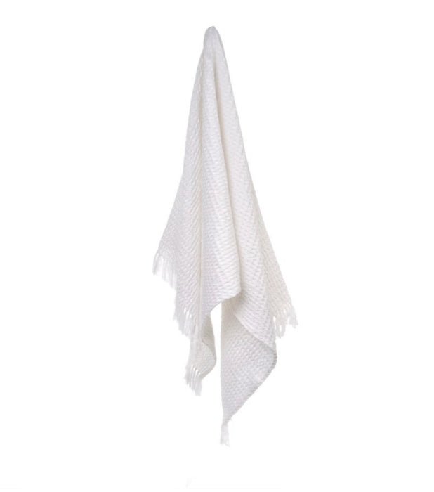 White Alys waffle weave bath towel. Artisan made in light weight, super absorbent cotton in a luxe waffle weave. Hand knotted fringe on each end.  34 x 70 inches. 100% cotton. 