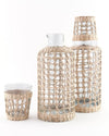 Seagrass Carafe shown with the small seagrass tumbler. Made of recycled glass and  wrapped in a hand woven seagrass cage. Add beautiful, natural texture to your tablescape. Each sold separately.
