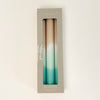 Set of 3 Dip Dye Candles inspired by the shoreline and hand dipped in shades of sand, seafoam green and turquoise add coastal color to your table setting. Set of 3 come packaged in a box, perfect for a hostess gift. Hand dipped paraffin candles measure 8" length, 3/4" diameter.