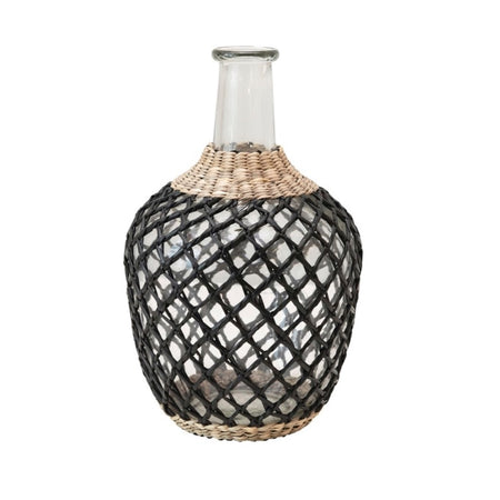 Mediterranean Seagrass Jug. Glass bottle is wrapped in hand woven black and natural seagrass cage. Measures 10.25"H, 5" diameter. Hand wash only.