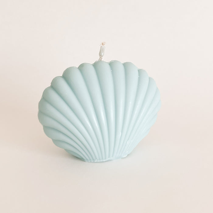Seaside Shell candle in blue adds calming beach vibes to any space. Hand poured by a female owned studio on California. Made of 100% unscented soy wax. Measures 3" H 4" W.