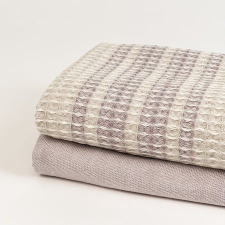 Lavender kitchen towels, set of 2. One solid lavender towel in a plain weave, the other a soft waffle weave in a cream and lavender stripe. An easy way to add a little soft color to a neutral kitchen. Measures 28" x 18".