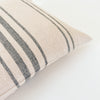 Close up detail of rustic texture on  pillow with navy stripes on an ecru ground.