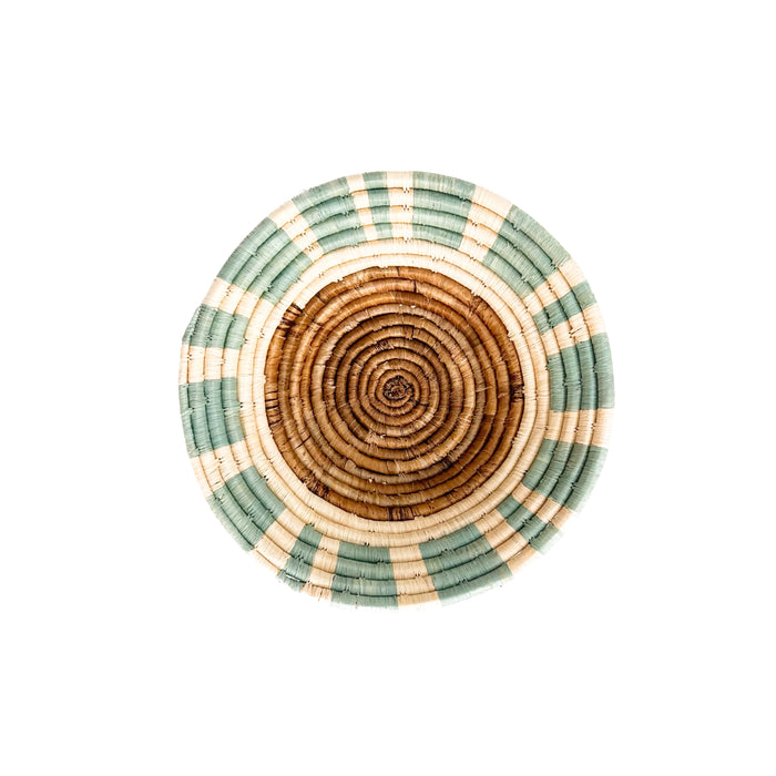 Dunes basket bowl. 10" diameter 2.75" depth. Hand woven in coils of hand dyed sweet grass and raffia in shades of seafoam green, natural and rust. 