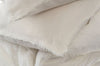 Close up of ivory linen pillow shams with gently frayed edges. 100% linen in ivory color. Sold as a set including 2 pillow shams and matching duvet cover. 