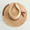 Top of the St. Barts Raffia Hat. Made of natural raffia with a portion of the brim wrapped and stitched with sepia colored cotton gauze. The crown has a striped jute band and sepia gauze tie. Hand crafted by La Macarena Hats.