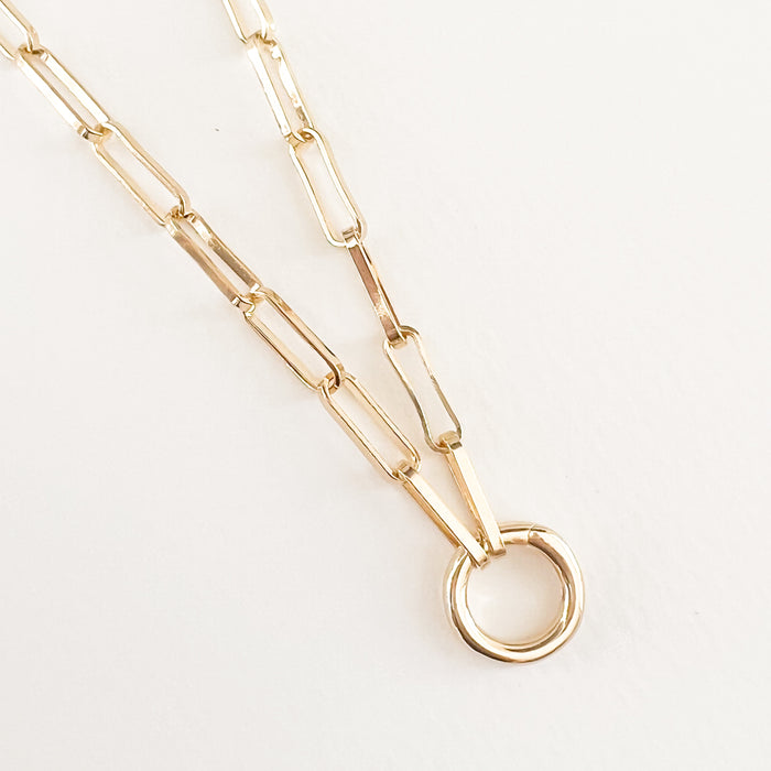 Liya charm builder necklace. 18K gold filled paperclip chain with a round carabiner intended for layering charms. 18" length. 
