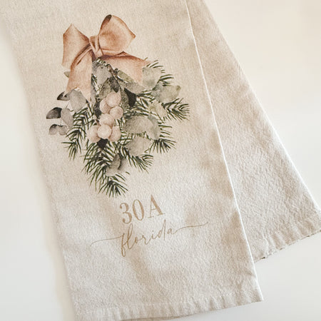 Neutral cotton tea towel printed with an evergreen swag and tan bow with custom "30A Florida" script. 21 x 28 inches.