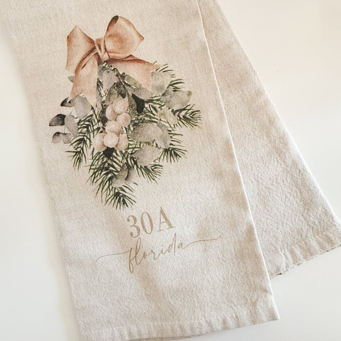 Neutral cotton tea towel printed with an evergreen swag and tan bow with custom "30A Florida" script. 21 x 28 inches.