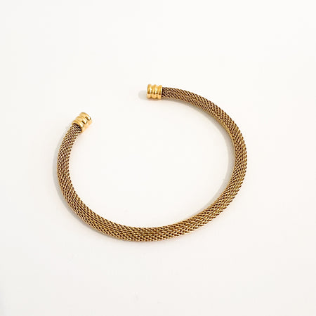 Sinclaire mesh cuff bracelet by Ellie Vail. Open ended gold mesh cuff with ridged gold end caps. 8" circumference. Sweat, water and tarnish resistant. Made of marine grade stainless steel with gold plating.