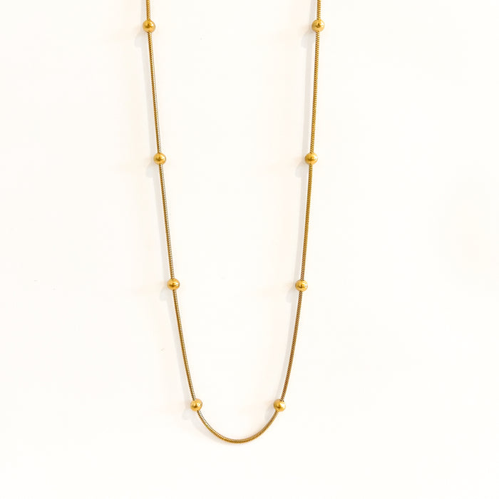 Rozlyn beaded ball necklace by Ellie Vail. Slim gold snake chain with small gold balls spaced around it. Sweat, water and tarnish resistant. Made of marine grade stainless steel with gold plating. 17" length.