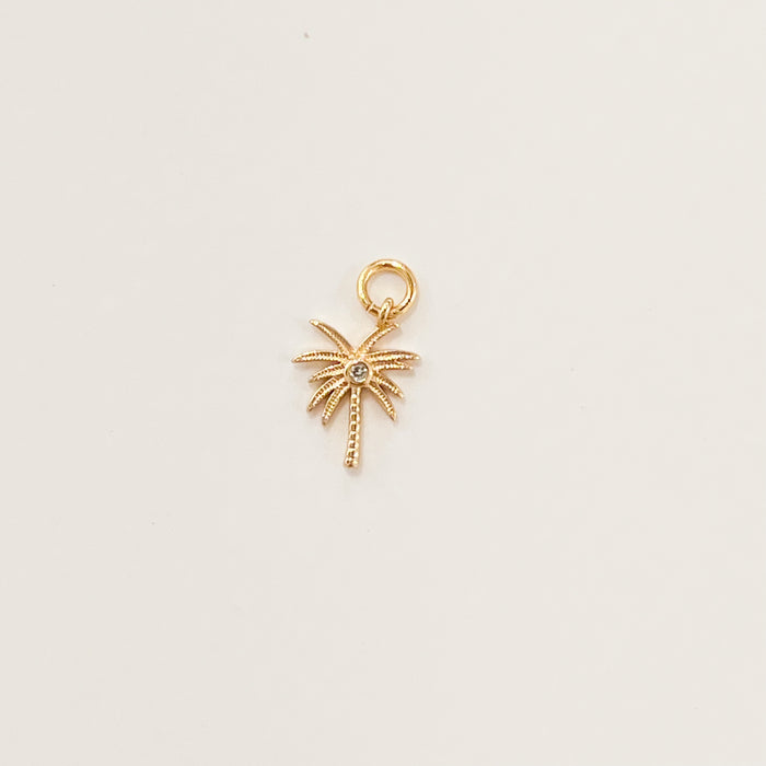 Mini golden palm tree charm with a clear CZ crystal inset in the center. Designed to mix and layer on our charm builder necklaces and earrings, sold separately. 14k gold filled. Measures 1/2 high 3/8" wide (at widest point).