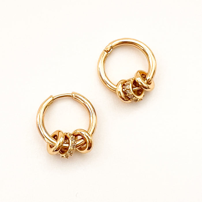 Sabine Huggies by Tai Jewelry. Small gold plated clicker hoops with 3 tiny gold rondells. Center rondell has clear CZ pave'. Measures 1/2" diameter.