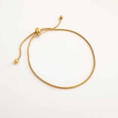 Lourdes adjustable gold snake chain bracelet by Ellie Vail. Slim snake chain with pull adjusters finished with gold beads. One size fits most. Sweat, water and tarnish resistant. Made of marine grade stainless steel.