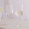 Pair of clear fluted wine glasses with white wine. Each glass sold separately. Measures 4" x 9.5". 19.88 oz/588 ml capacity.