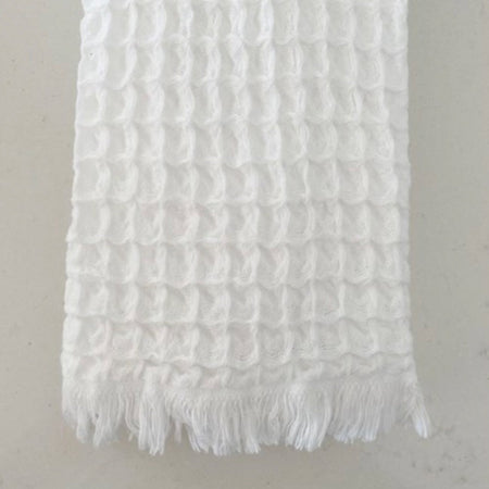 White luxe waffle weave hand towel. 100% cotton waffle weave weave with fringe ends. Made in Turkey. Measures 13" x 35".