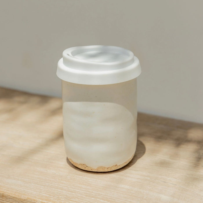 Wabi ceramic "To Go" mug. Hand crafted of natural sand stoneware and finished with a creamy white glaze. White silicone to go lid. 8 oz. mug. 3" diameter 4" high.