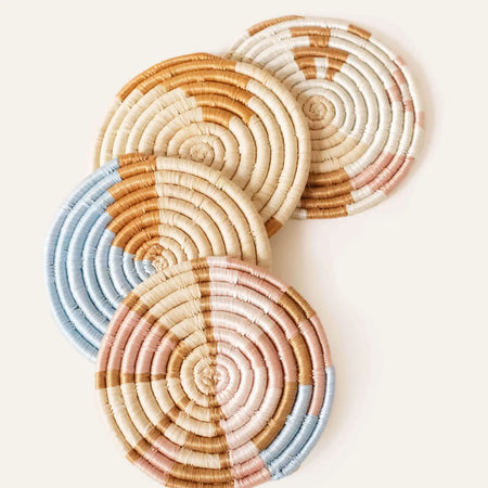 Set of 4 seagrass coasters in an abstract pattern in a mix of natural seagrass,  blue, pink, white and cream. Set of 4. 4 inch diameter.