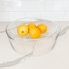 Aero glass serving bowl holding 4 lemons.  Clear glass serving bowl with a curved concave surface ideal for the modern kitchen. Measures 11.75" diameter x 4.25" height. Holds 16 oz. Lemons not included.