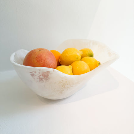 Organic shaped white fruit bowl with lemons, an orange and a grapefruit. Made of white resin with a marble effect similar to Alabaster. Measures 13.4" x 9.8" x 6.3" height