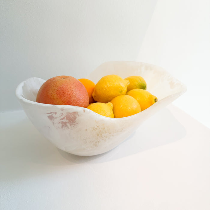 Organic shaped white fruit bowl with lemons, an orange and a grapefruit. Made of white resin with a marble effect similar to Alabaster. Measures 13.4" x 9.8" x 6.3" height