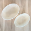 Two white resin oval shaped platters on a pale wood table. Large 14 x 10 inches. Medium 11.5 x 7 inches. Each sold separately.