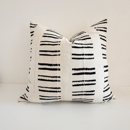 An ivory and black African mudcloth pillow on a white background. 24 inch square with down insert. Vintage textile.