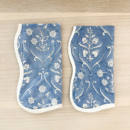 Pair of cornflower blue block print napkins  with a white floral motif and white scalloped edges. 100% cotton. Hand block printed. Set of 2. 12" x 12".