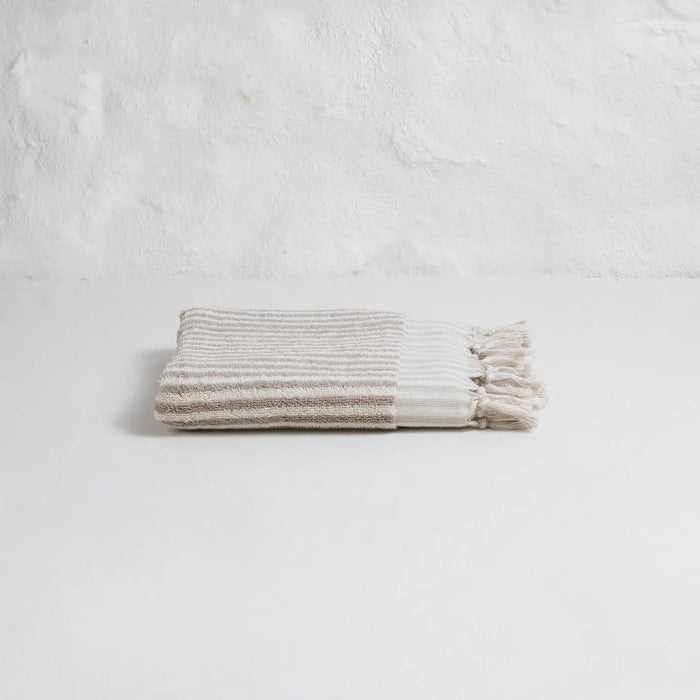 Taupe and ivory stripe hand towel with hand knotted fringe edges. 100% Turkish cotton.