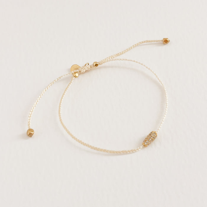 Chloe cream corded bracelet with gold filled cylinder encrusted with tiny CZ crystals. Adjustable, one size fits most. Hand crafted by TAI Jewelry.