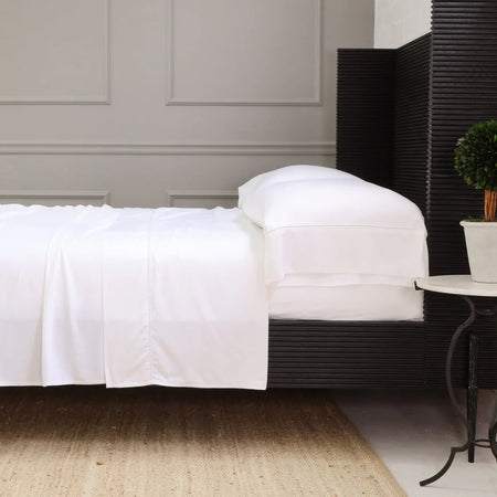 White sateen bamboo bedding styled on black bed. All bedding by Pom Pom at Home.