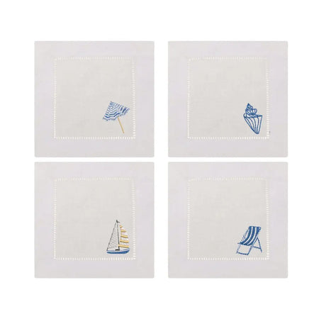 Set of four white linen cocktail napkins with embroidered coastal designs on the lower right corner. Designs include a striped beach umbrella, a seashell, a sail boat and a striped beach chair. 6 inch square.