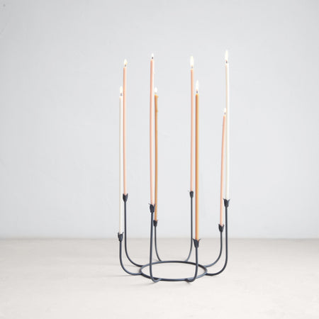 Black wrought iron candelabra holding eight slim taper candles. Tulip shaped candle cups. Measures 10 inch diameter x 7 inch height.