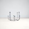 Round black wrought iron candelabra inspired by garden gates. Candle cups shaped like tulips. Holds eight slim taper candles. 10 inch diameter x 7 inch height.