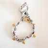White and brown braided bandana bracelet with five golden spring clasps designed to hold charms.