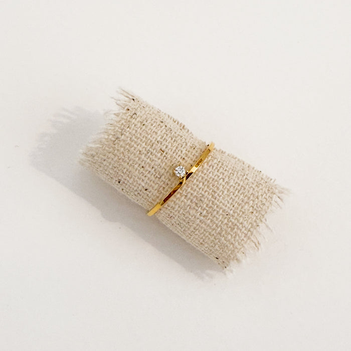 Delicate gold ring with a unilateral solitaire CZ stone. Water, sweat and tarnish resistant.