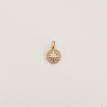 Gold filled compass charm with small clear CZ crystal in the center. Designed to layer onto any charm builder necklaces or earrings. Measures 3/8" diameter.