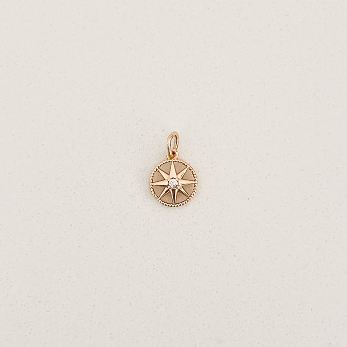 Gold filled compass charm with small clear CZ crystal in the center. Designed to layer onto any charm builder necklaces or earrings. Measures 3/8" diameter.