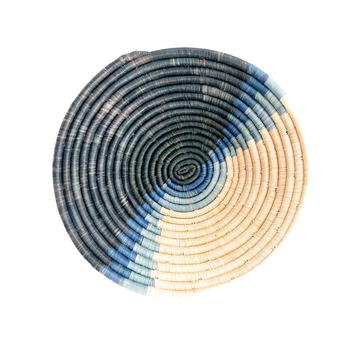 Coastal blues basket bowl, size medium. Hand dyed sweet grass and raffia in shades of dark to light indigo combined with natural raffia are intricately woven into coils forming this bowl. Measures 12" diameter 3.5" depth.