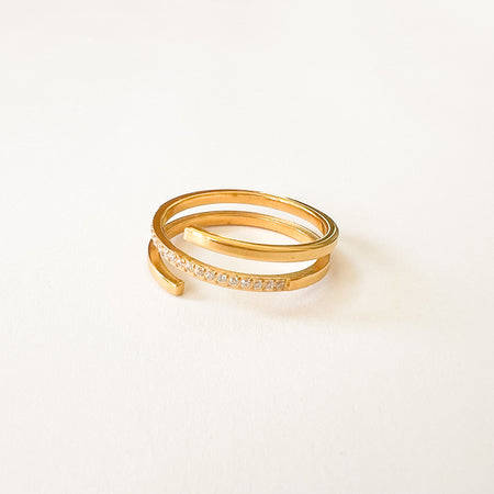 Giselle Spiral Ring by Ellie Vail. Open ended gold spiral ring with clear CZ pave' set in middle band. One size fits most. Sweat, water and tarnish resistant. Made of marine grade stainless steel with gold plating and CZ stones.