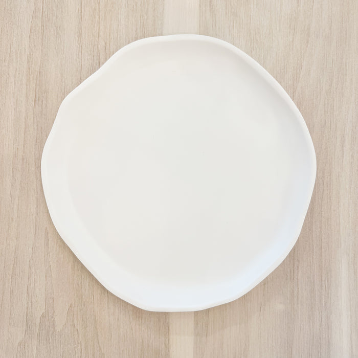 White melamine "Cloud" dinner plate. Part of the Nube collection by Beatrix Ball. Irregular organic shape with a matte white finish. Measures 11" diameter. 