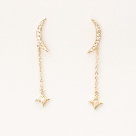 Celestial drop earrings. Two gold crescent moon stud earrings encrusted with tiny clear CZ stones with a delicate chain drop featuring a gold star centered with a shimmering white Opal stone. 18K gold plating over brass, CZ stones, white Opal with sterling silver posts. Hypoallergenic and lead free. Total length 1/5", crescent moon stud 5/8" length.