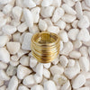A cluster of gold wires wrapped into a ring on white pebbles. 18k gold over brass.