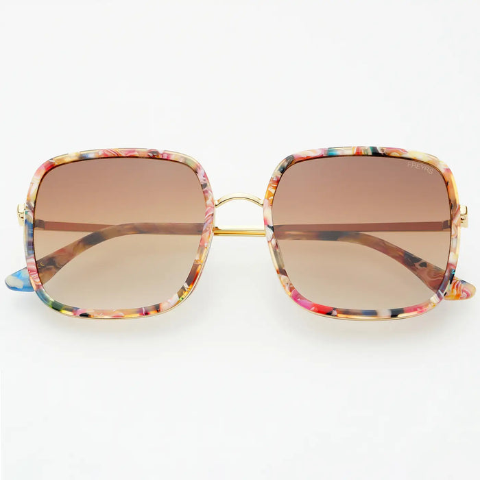 Sunglasses with pink toned tortoise frame and softly tinted brown lenses on a white background.