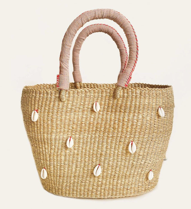 Straw beach tote hand woven in Elephant grass with white cowrie shells scattered on front and back with a soft pink cloth handle. Artisan made in Ghana. 16 inch length x 9 inch height x 6.5 inch dept (5.5 inch handle drop).