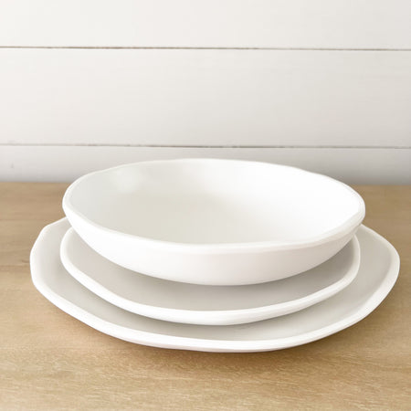 "Cloud" table setting. Dinner plate, salad plate and pasta bowl in white melamine. Part of the Nube collection by Beatrix Ball featuring modern organic silhouettes with a matte white finish. Each piece sold separately.