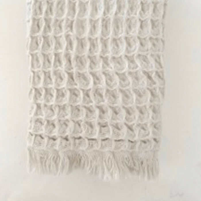 Sand colored luxe waffle weave hand towel. 100% cotton waffle weave with fringe ends. Made in Turkey. Measures 13" x 35".