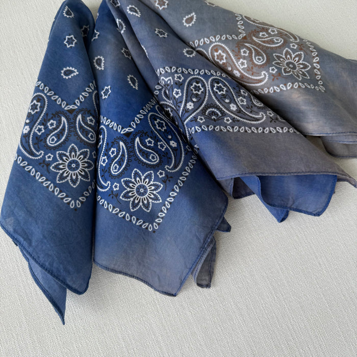 Collection of hand dyed cotton bandanas in tonal shades of indigo blue with classic bandana patterns in white and brown.