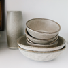 Stack of ceramic bowls with a small ceramic carafe. All part of the Drift Stoneware collection. Each pieces sold separately.
