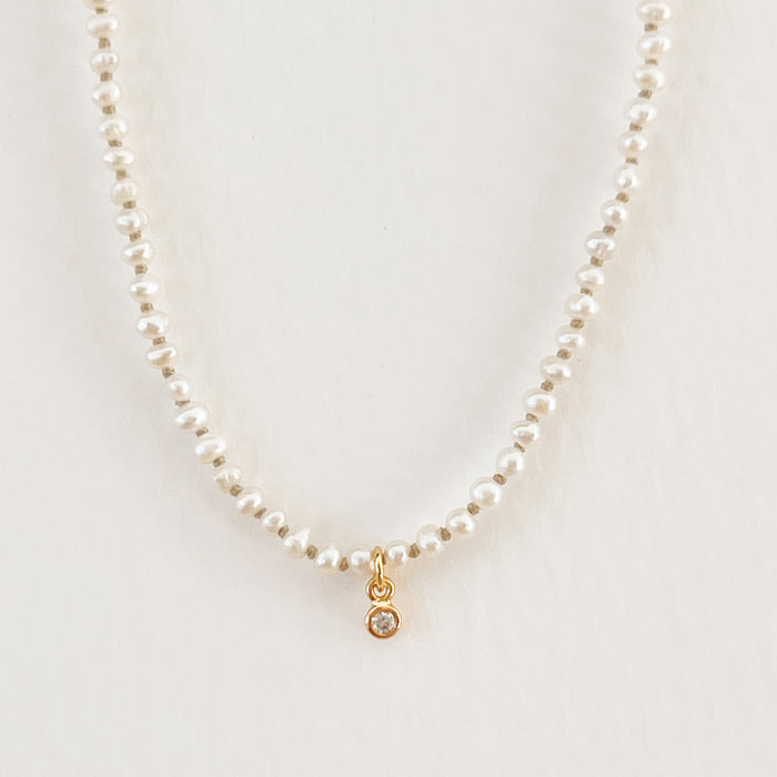 Petite white pearl necklace with a gold filled and CZ crystal charm. 15" length with a 2" extender.